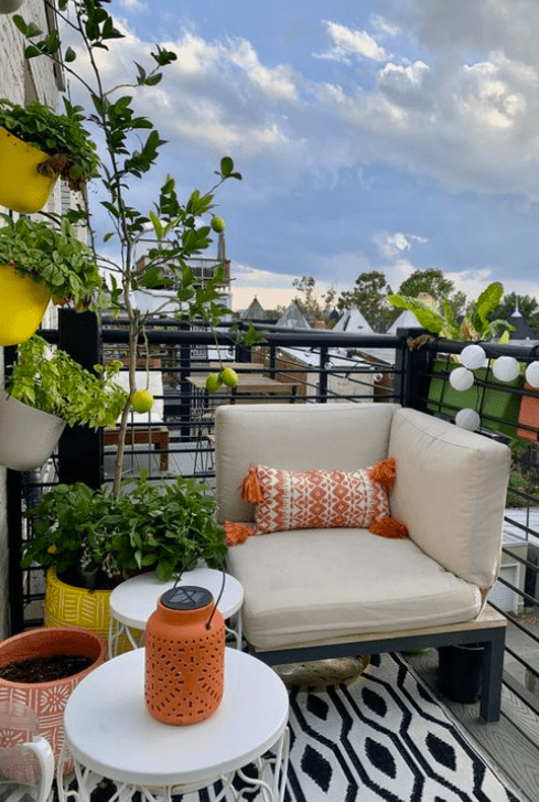 corner seating on a balcony with plants and orange decor