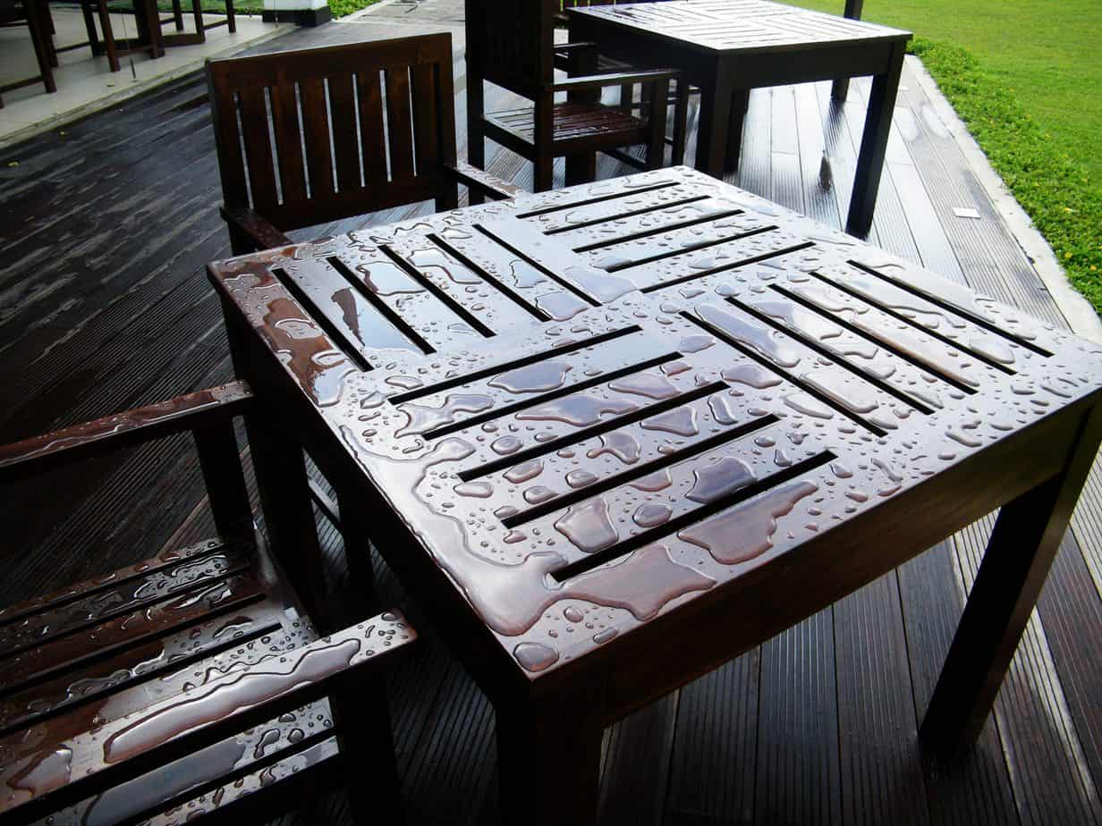 an outdoor brown table getting soaked with water