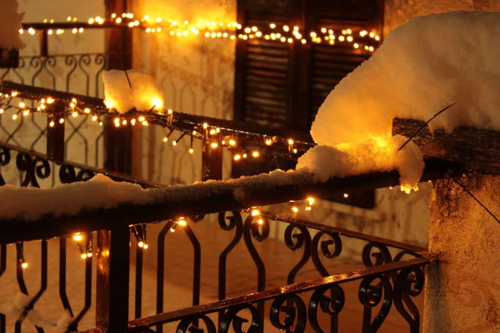 string lights on a balcony at night in the snow